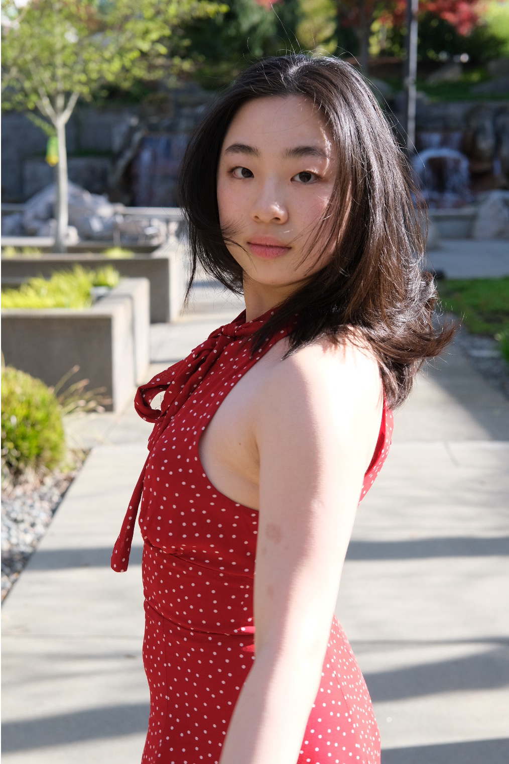 Portrait of Winnie Ma in a red dress outdoors in afternoon light